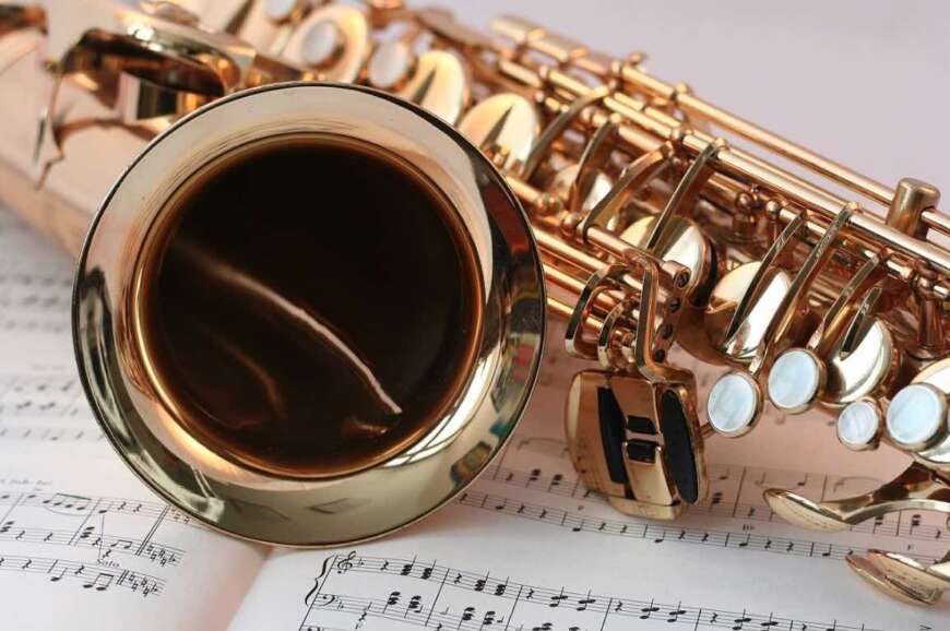 Ein Saxofon liegt auf einer aufgeschlagenen Partitur.