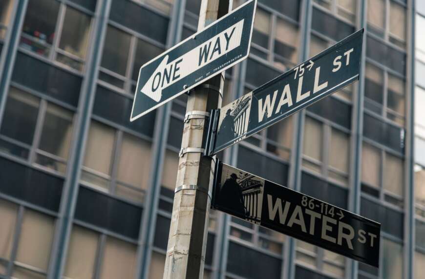 Straßenschilder auf denen Wall Street steht