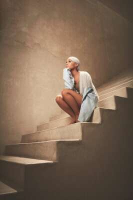 Ariana Grande in der Hocke auf einer Treppe