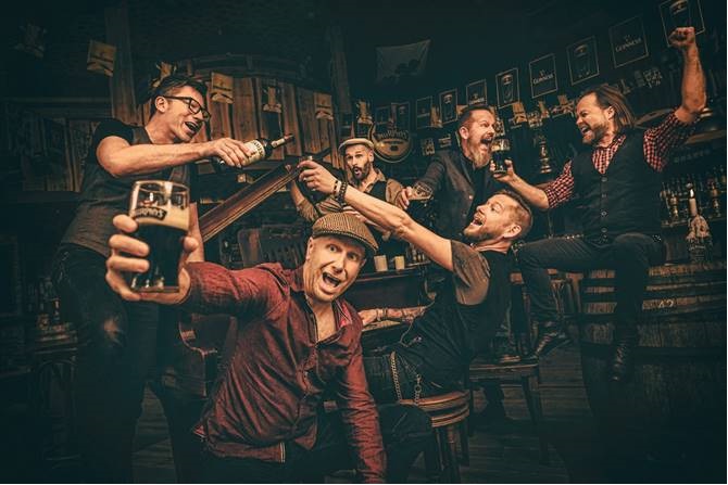 Die Bandmitglieder von Fiddler's Green lassen es sich in einem gemütlichen Pub gut gehen.