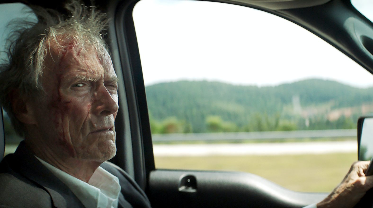 Szenenbild aus „The Mule“: Clint Eastwood sitzt am Steuer eines Autos und starrt grimmig in die Kamera