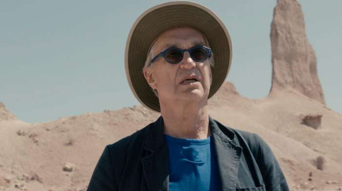Wim Wenders während der Dreharbeiten zu "Desperado": Ein Mann mit Hut und blauer Sonnenbrille vor karger Landschaft