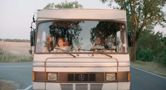 Szenenbild aus „303“: Jan (Anton Spieker) und Jule (Mala Emde) fahren im Mercedes 303 Bus.