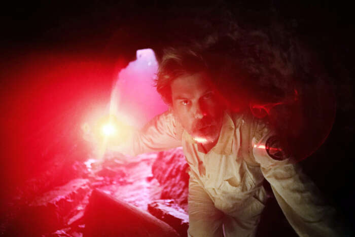 Angus Andrew alias Liars in einer Höhle mit seltsamen rotem Licht