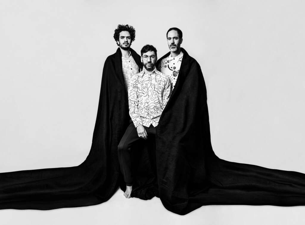 Omer Klein Trio Schwarzer Umhang Weißer Hintergrund