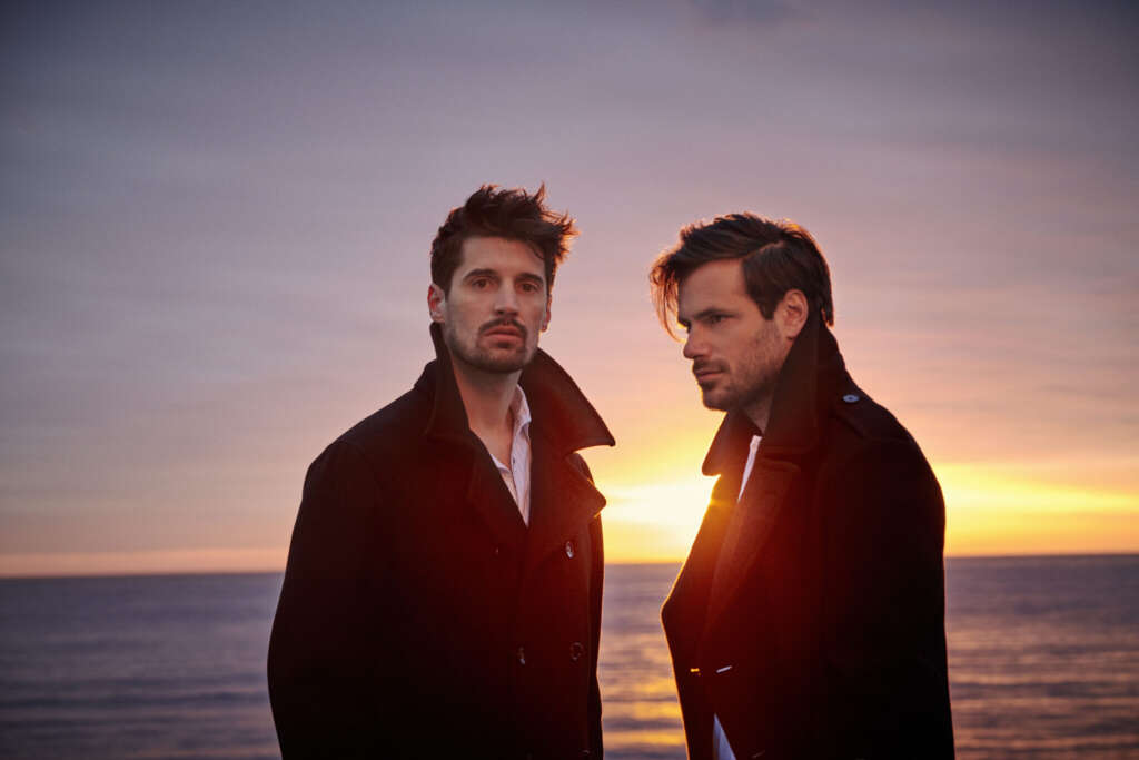 2 Cellos Bandmitglieder Vor Sonnenuntergang in Mänteln