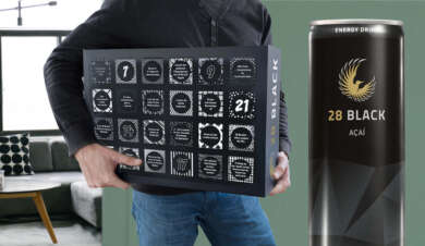 Mann mit 28 Black Adventskalender unter dem Arm.