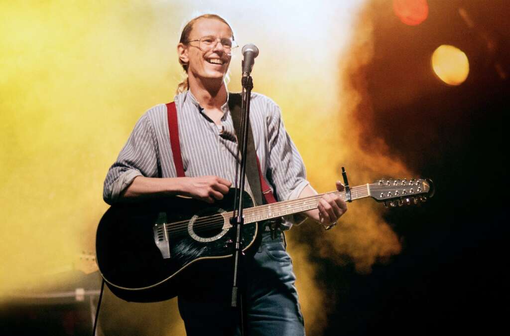Gundermann (Alexander Scheer) mit Gitarre auf der Bühne.