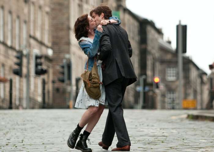 Eine Frau und ein Mann küssen sich auf der Straße.