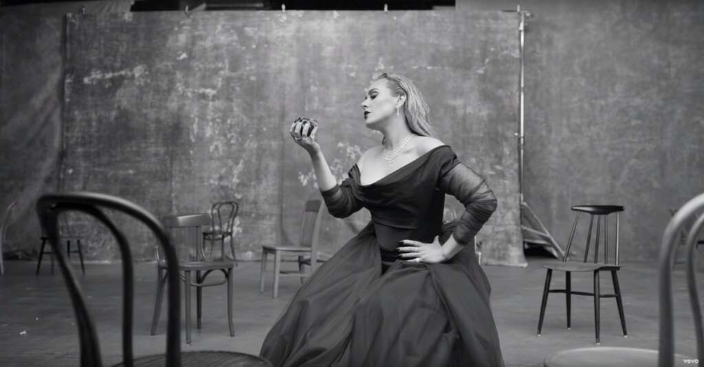 Adele posiert in großer Robe mit einem Apfel für ihr neues Musikvideo „Oh my God“