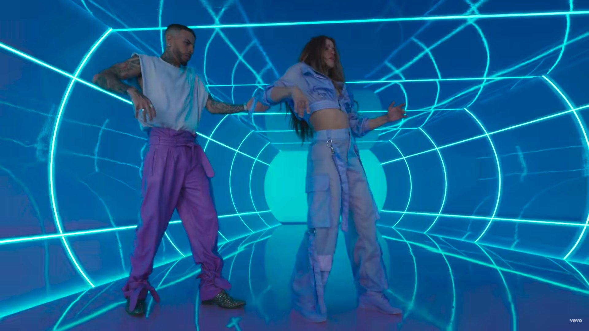 Shakira und Rauw Alejandro tanzen im Video zu „Te Felicito“ als Roboter in einer beleuchteten Röhre.
