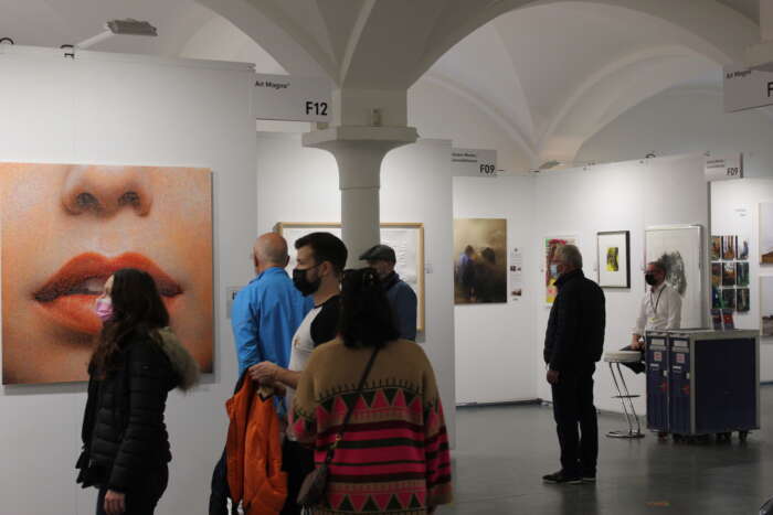 Blick in ein Ausstellungsgewölbe mit Kunst und Besucher:innen der ARTMUC 2022.