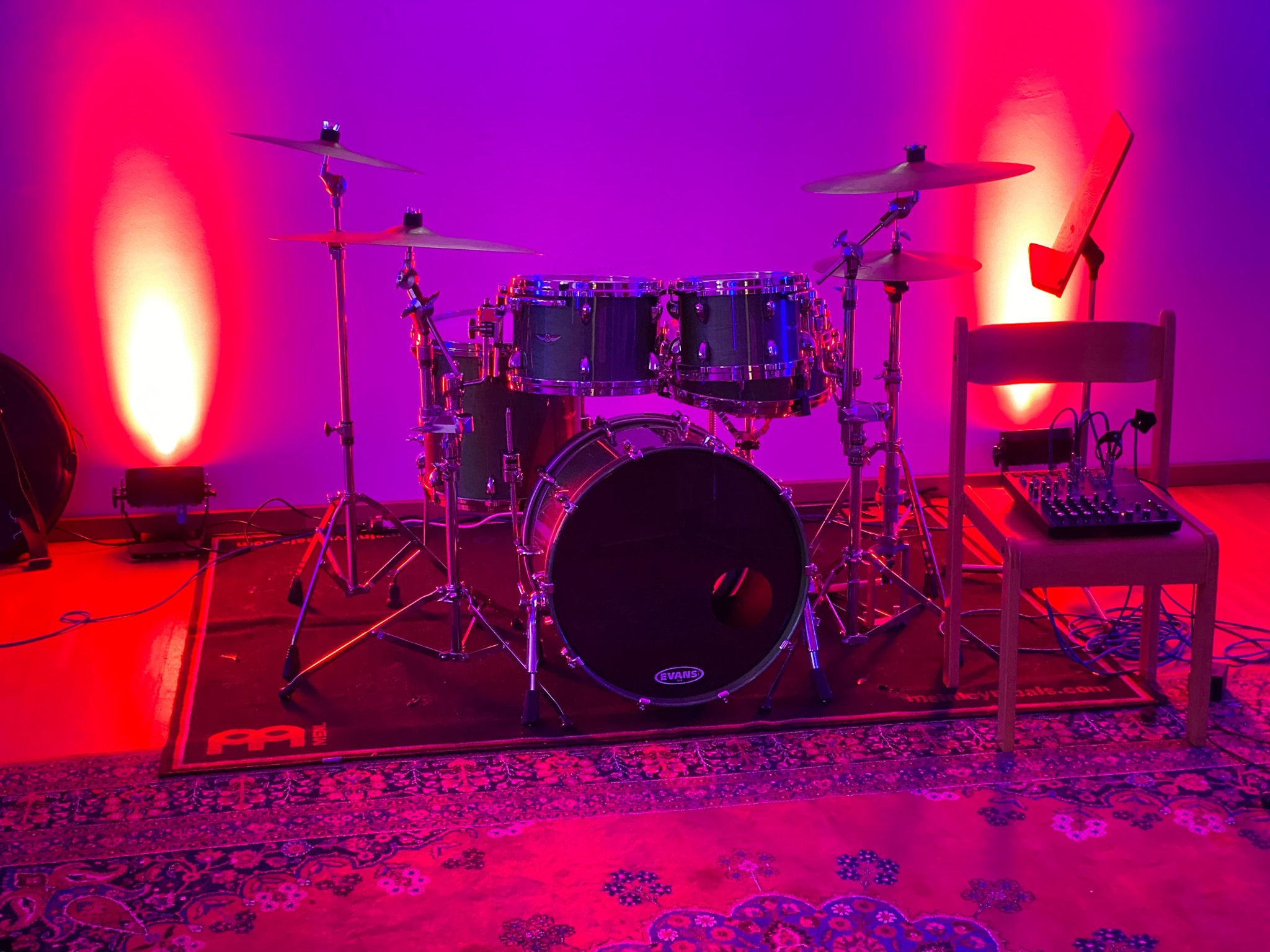 Musik-Workshop: Zu sehen ist ein Schlagzeug in lila-pinker Beleuchtung.