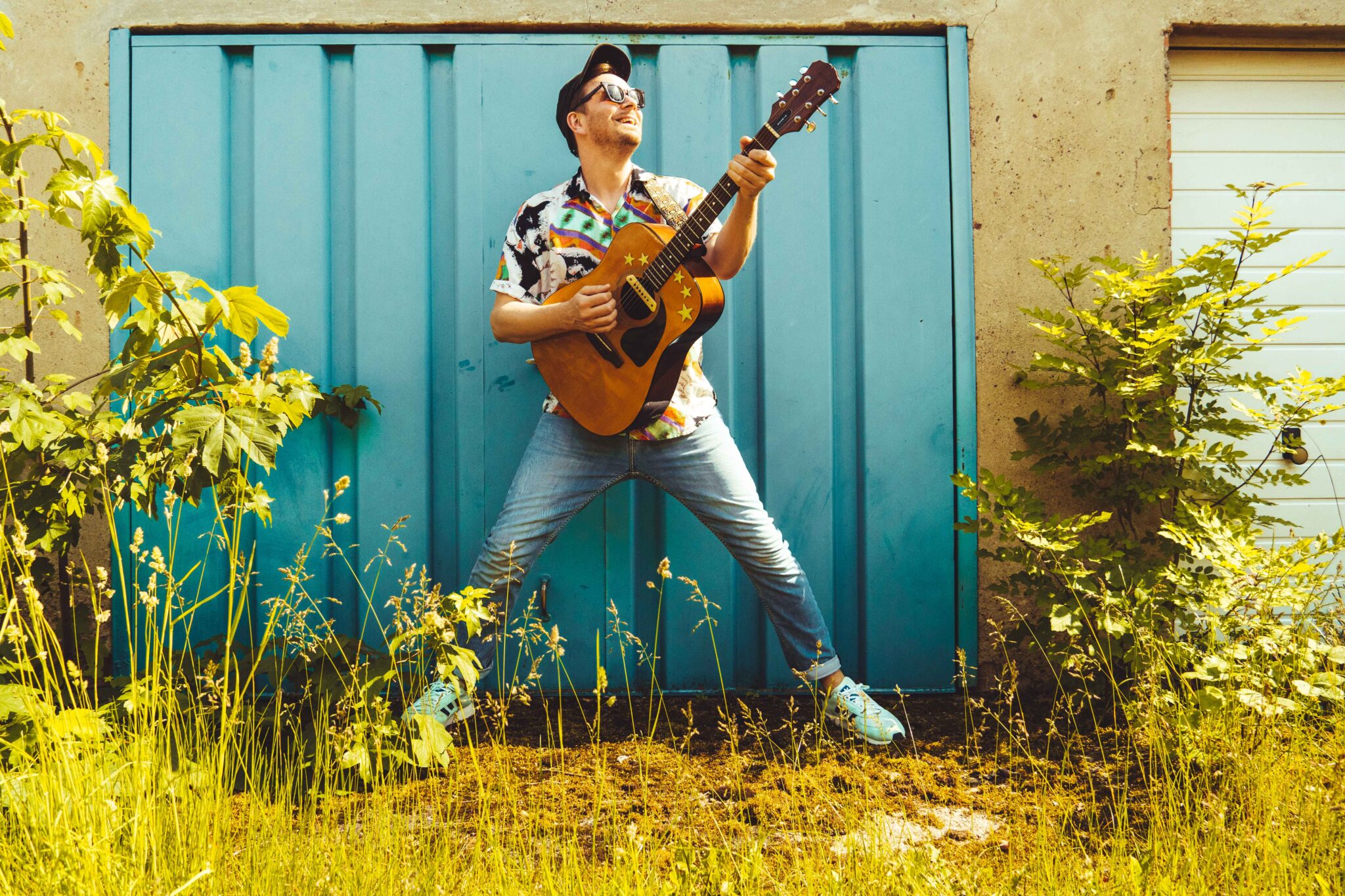 Kowsky Portraitfoto mit Gitarre im Garten