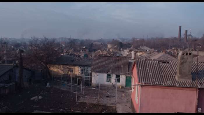 „Mariupolis 2“: Man sieht den Blick über die Hafenstadt Mariupolis, die teilweise in Trümmern liegt, teilweise stehen ein paar niedrige Häuser noch.