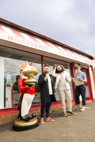Zu sehen ist die dreiköpfige, rein männliche band „Normal Fears“ ist vor einem britischen Eisladen zu sehen.
