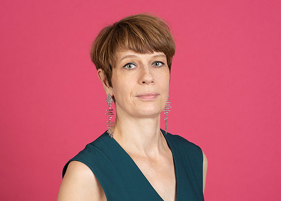 Die neue Leitung der Perspektive Deutsches Kino der Berlinale, Jenni Zylka. Eine Frau in grünem kleid vor rosa Hintergrund ist zu sehen.