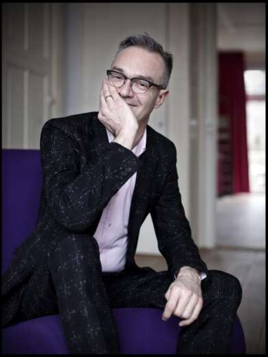 Portraitfoto Marcel Möring sitzend auf lila Sofa