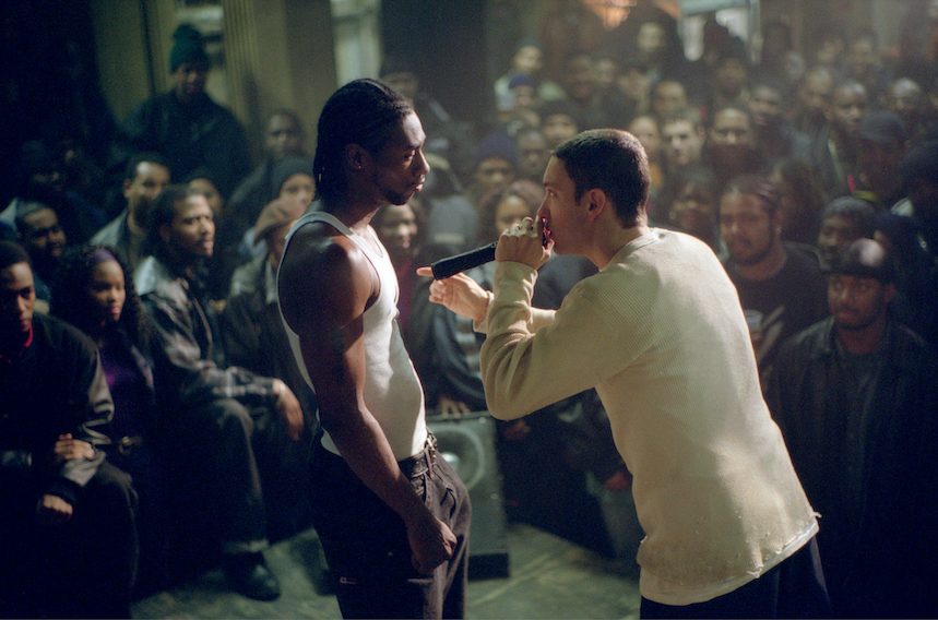 Ein Still aus „8 Mile“: Zwei Männer stehen auf einer Bühne, im Hintergrund ist ein Publikum zu sehen. Rechts steht Rabbit, gespielt von Eminem, mit einem Mikrofon in der Hand, ihm Gegenüber sein Rivale Lotto (Nashawn Breedlove).