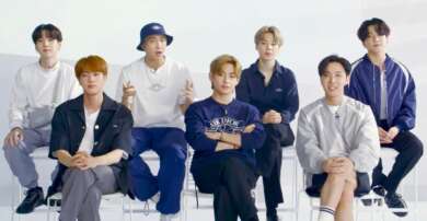 BTS Serien: Man sieht die 7 Mitglieder der Gruppe, sie sitzen in 2 Reihen auf Stülen. In der hinteren Reihe sitzen 4 Mitglieder etwas erhöt, in der vorderen Reihe nur 3.