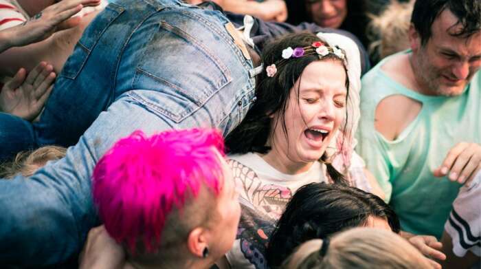 Still aus „Das Leben danach“: Antonia (Jella Haase) steht inmitten einer Menschenmenge. Sie trägt einen Blumenkranz im Haar und weint.