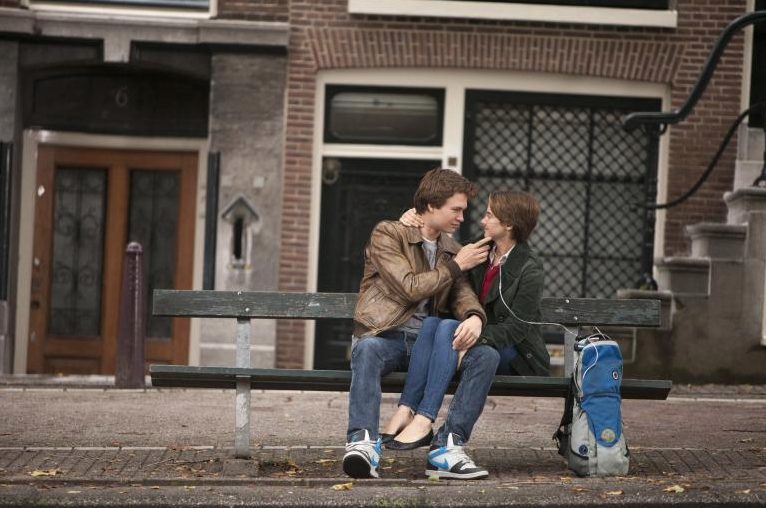 Still aus „Das Schicksal ist ein mieser Verräter“: Augustus und Hazel sitzen auf einer Bank und schauen sich tief in die Augen.