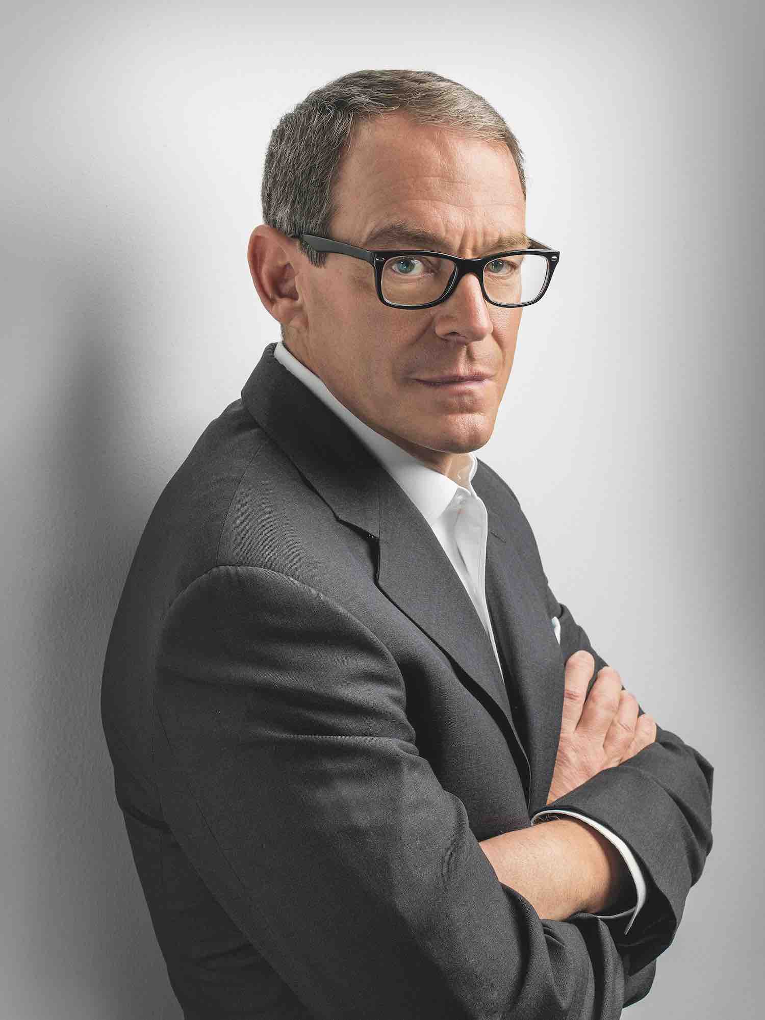 Daniel Silva, Autor von „Die Cellistin“, im grauen Anzug mit schwarzer Brille porträtiert.
