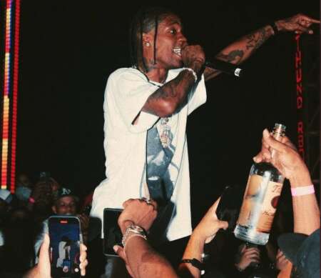 Zu sehen ist Travis Scott auf der Bühne bei einer Performance.
