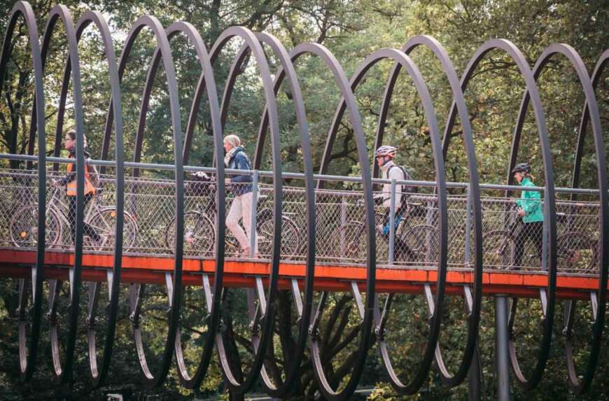 Menschen schieben ihre Räder über eine Brücke