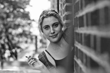 „Frances Ha“ auf One: Man sieht ein s/w-Bild von Greta Gerwig, sie lehnt sich aus einer Tür raus und hält eine Zigarette in der Hand.