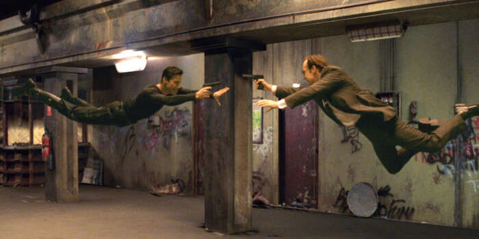 Matrix: Keanu Reeves Neo und Erzefeint Agent Smith fliegen aufeinander zu durch die Luft.