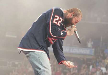 Post Malone zeigt dem Loch, durch das er fiel, scherzhaft den Mittelfinger.