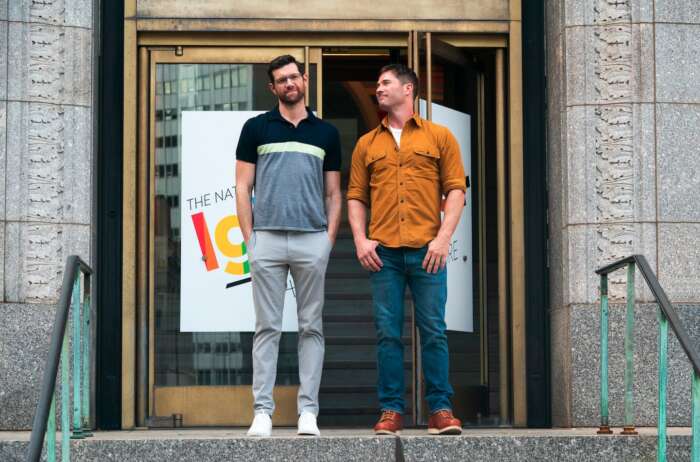 Billy Eichner und Luke Macfarlane stehen stehen vor einem Gebäude