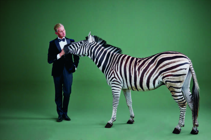 Max Raabe wie gewohnt im schwarzen Anzug posiert mit einem Zebra namens Mango