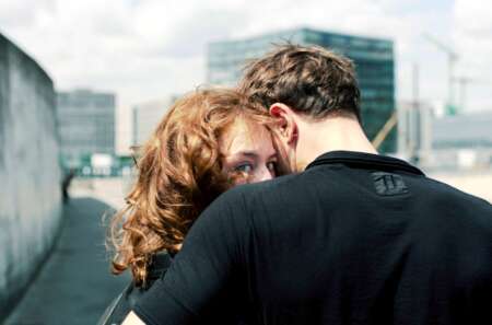 Still aus „Undine“: Ein Mann und eine Frau umarmen sich, die Frau blickt direkt in die Kamera.