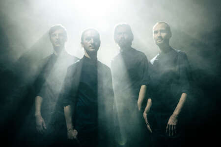 Norlyz: Alle vier Bandmitglieder stehen unter einem Lichtkegel.