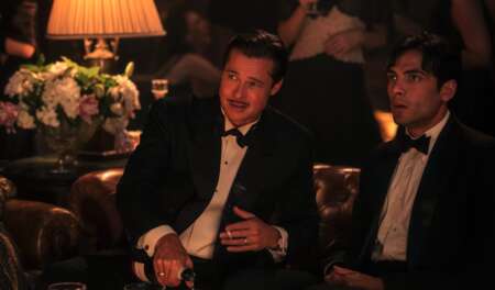 Brad Pitt und Diego Calva sitzen in Abendgarderobe in einem Klub
