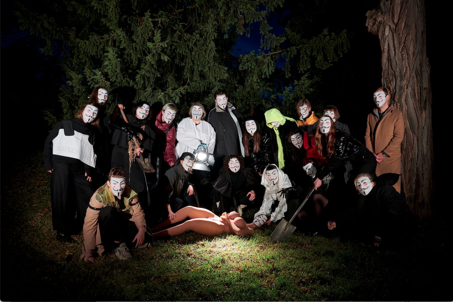 Aktivist:innen mit Guy-Fawkes- Masken im nächtlichen Wald
