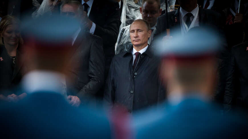 "ZDFzeit: Putins Komplizen - Die geheime Welt der Oligarchen": Putin in dunkelblauem Regenmantel zwischen der unscharfen Silhouette zweier Soldaten bei einer Militärparade in Belgrad 2016.