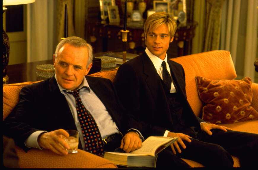 "Rendezvous mit Joe Black": Wiliam (Anthony Hopkins) sitzt links von Joe (Brad Pitt) auf einer Couch. Beide tragen schwarze Anzüge und blicken in eine Richtung.