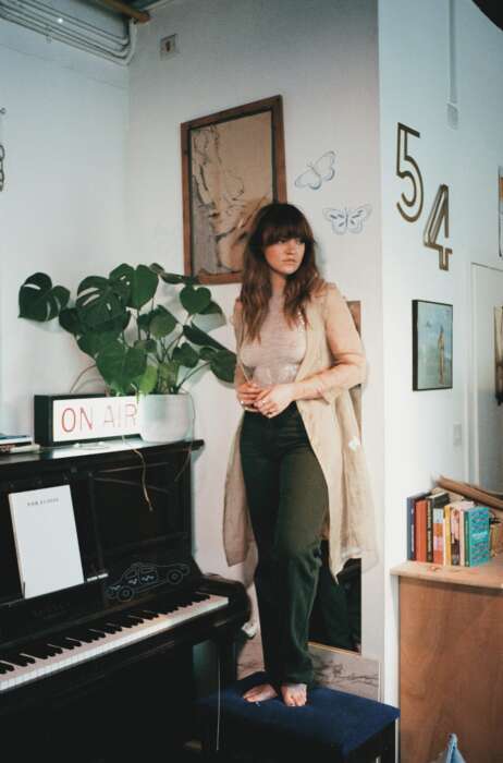 Eloise steht in einem Zimmer mit Klavier. Dort liegen Noten mit dem Titel „For Eloise“.