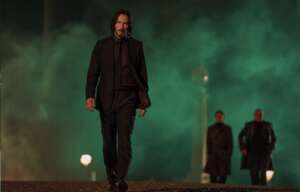 Keanu Reeves geht nachts über eine Straße. John Wick 4