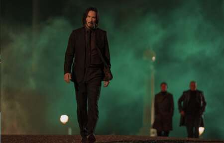 Keanu Reeves geht nachts über eine Straße. John Wick 4