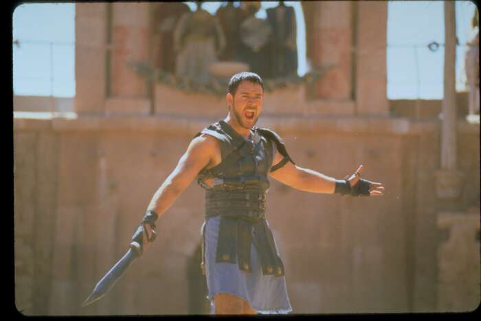 "Gladiator": Maximus (Russell Crowe) steht mit weit ausgebreiteten Armen, schreiend und mit einem Dolch in der Hand, in der Arena.
