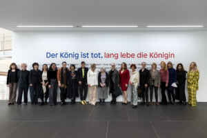 Eine Gruppe Frauen steht vor einer Wand und schaut in die Kamera