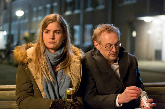 "Arthur & Claire": Arthur (Josef Hader) und Claire (Hannah Hoekstra) sitzen in nächtlicher Stunde dicht nebeneinander auf einer Bank.