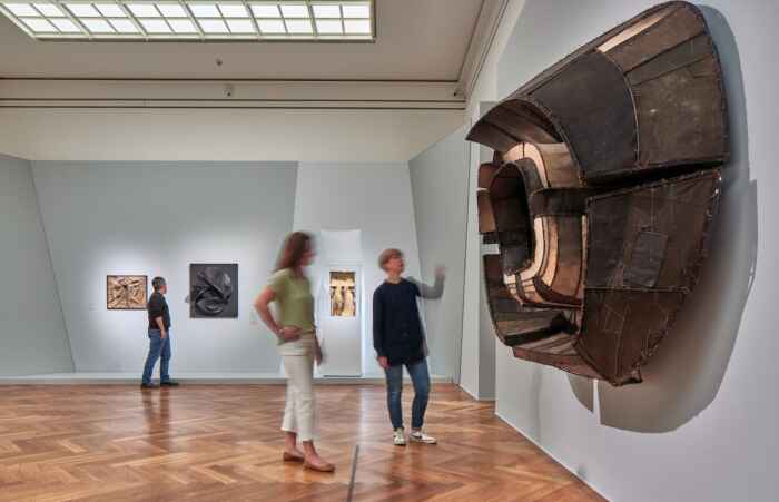Zwei Frauen stehen in einem Museum vor einem Kunstwerk