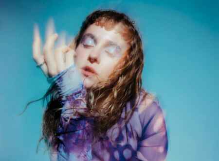 Moyka, die ihre neue Singe „Don’t turn around“ veröffentlicht, etwas verschwommen, vor einem blauen Hintergrund.