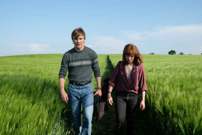 "Verräter - Tod am Meer": Martin (Albrecht Schuch) und Nina (Hannah Herzsprung) laufen nebeneinander durch ein grünes Feld.