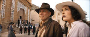 Ein Mann und eine Frau mit Hut gucken erstaunt nach links. Indiana Jones und das Rad des Schicksals